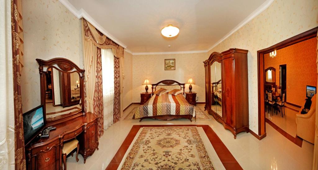 - une chambre avec un lit, une commode et une télévision dans l'établissement Гранд Алексік, à Trouskavets
