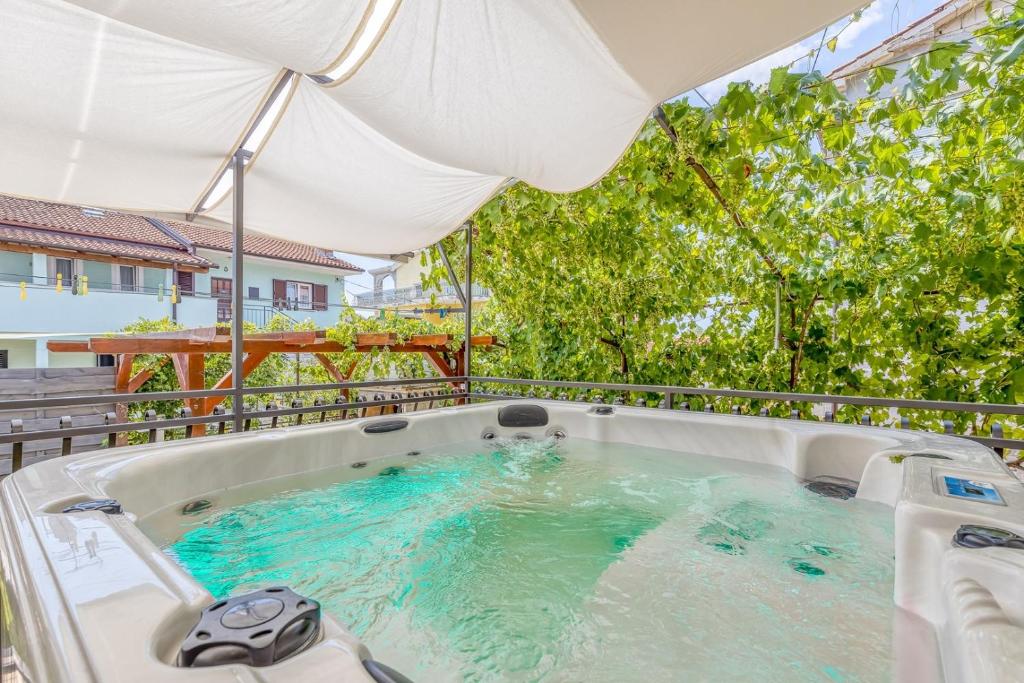 a hot tub on a balcony with trees at Wellness Apartment in Poreč