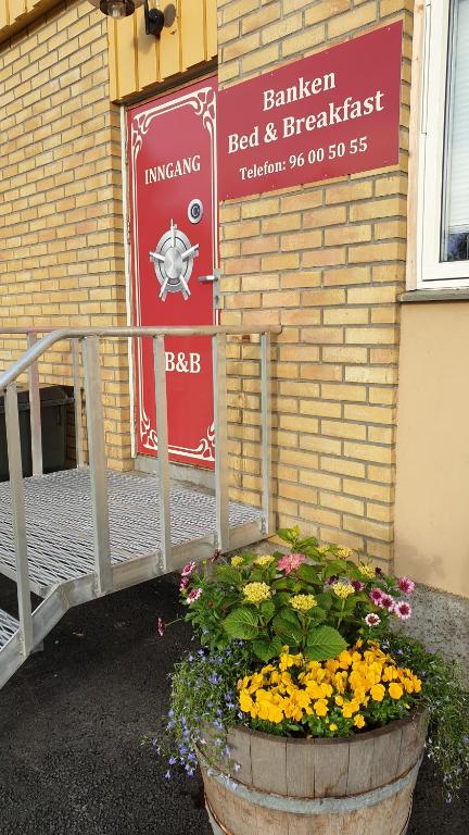a sign on a building with a pot of flowers at Banken Bed & Breakfast 
