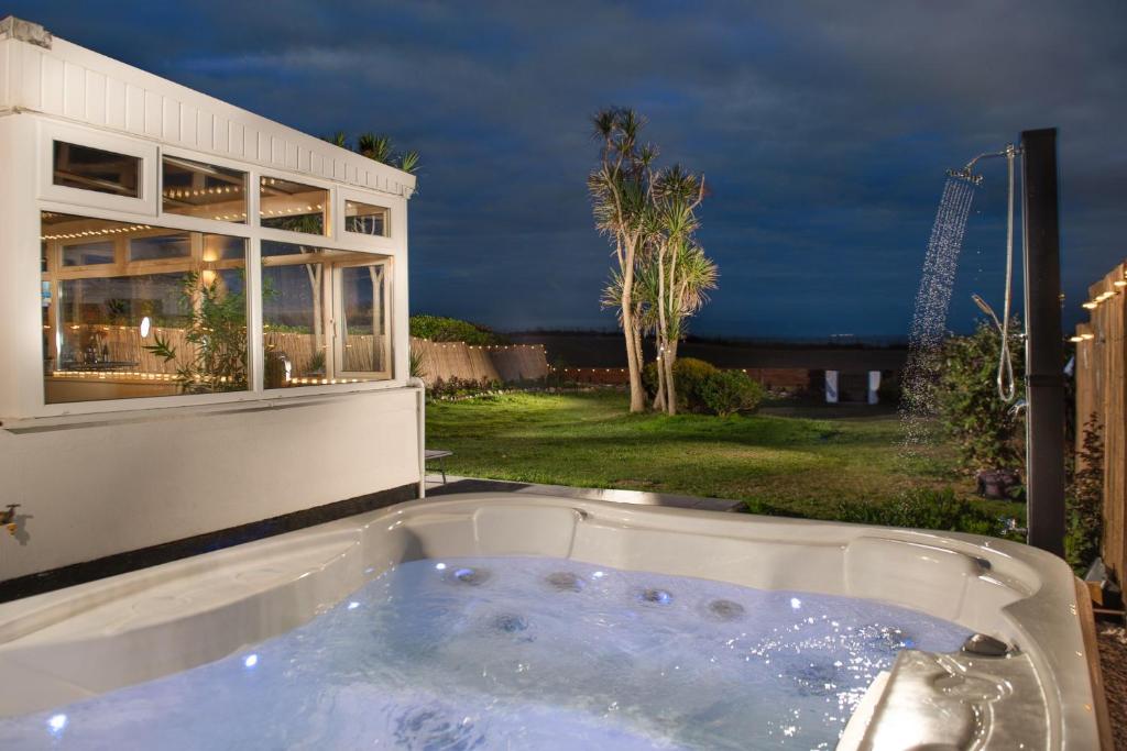 a jacuzzi tub in the backyard of a house at Kerenza Sands, Praa Sands in Praa Sands