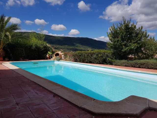 una gran piscina azul con una montaña en el fondo en Vivienda Rural Casa Sofía en Ubrique