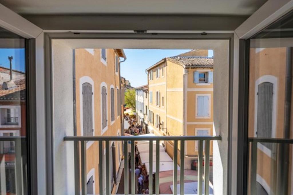 a view of a city street from a window at Appartement à L'Isle-sur-la-Sorgue avec vue sur la ville in LʼIsle-sur-la-Sorgue