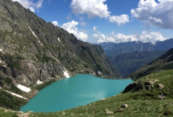 a blue lake on the side of a mountain at Gran Paradiso huge apartament in Locana in Locana