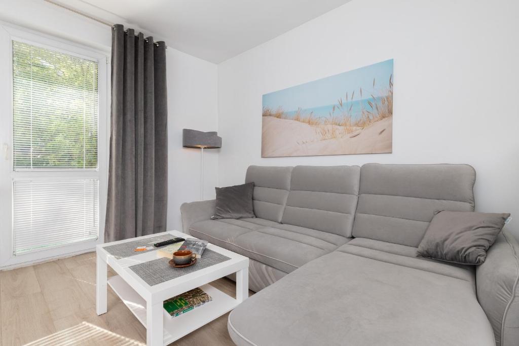 a living room with a couch and a table at Gdańska Two-bedroom Apartment Brzeźno Beach by Renters in Gdańsk