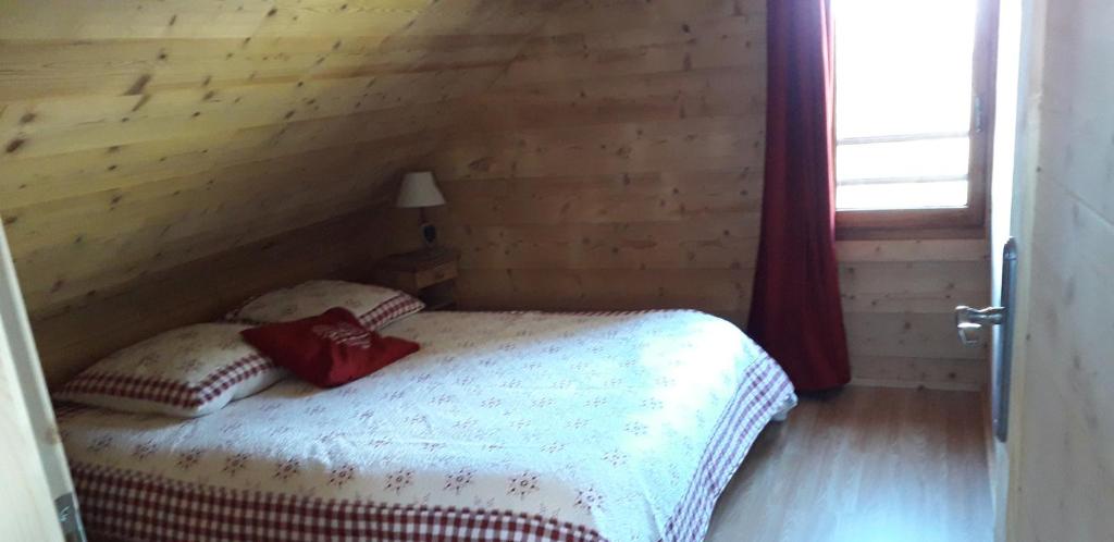 ein Schlafzimmer mit einem Bett in einem Holzzimmer in der Unterkunft Chalet cocody jacuzz in Jausiers