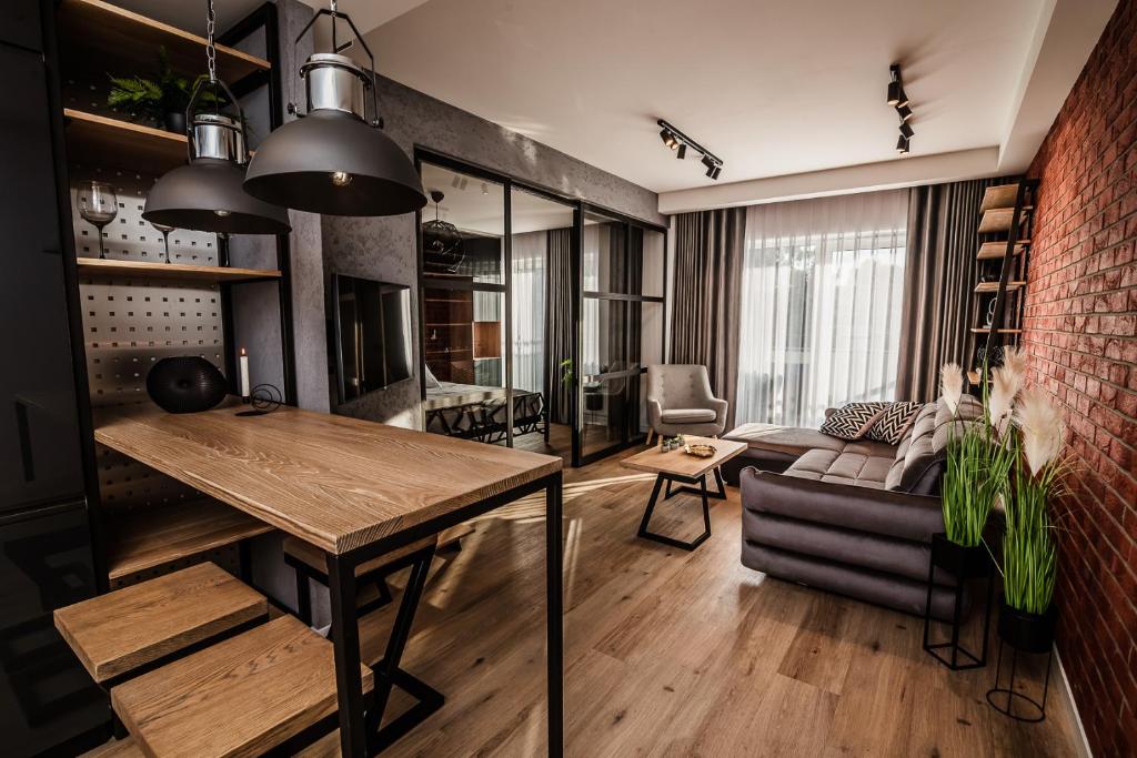 a living room with a table and a couch at Loft Apartament Aleje Wolności Nowy Sącz in Nowy Sącz