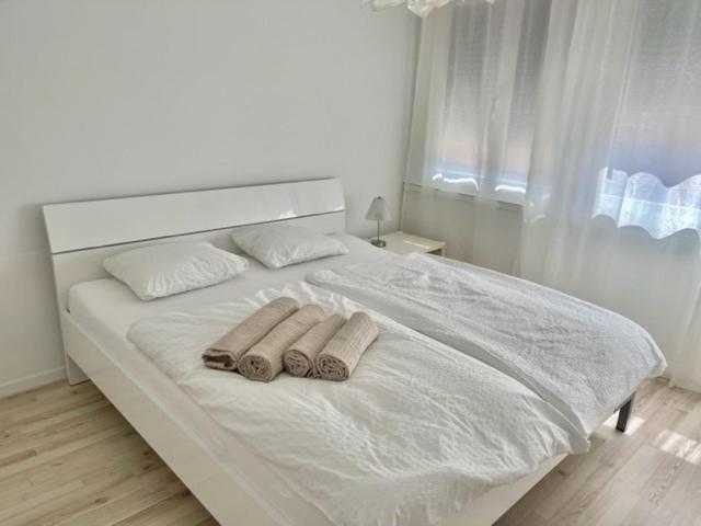 una camera da letto bianca con due asciugamani su un letto di Aufenthalt im Herzen von Luzern a Lucerna