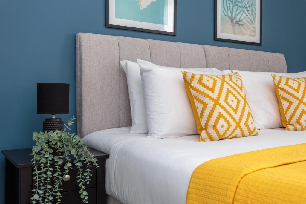 uma cama com almofadas brancas e um cobertor amarelo em Lovely 2-bed upper villa in Kirkliston Edi Airport em Edimburgo