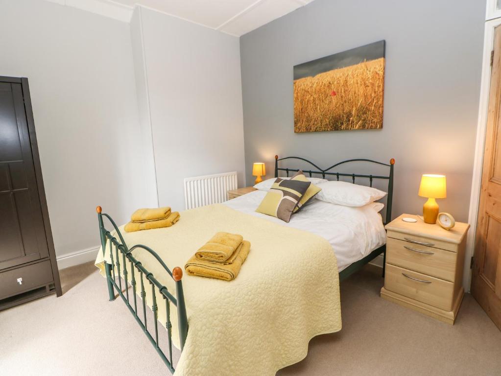 a bedroom with a bed and a dresser with towels on it at Church View Cottage in Bishop Auckland