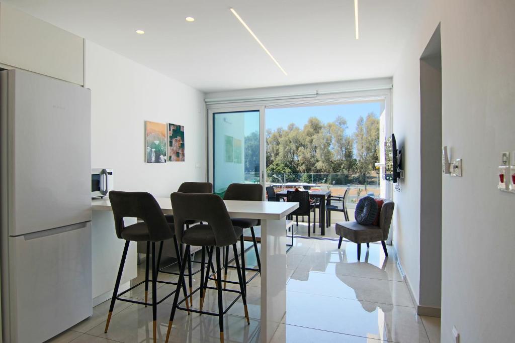 cocina y comedor con mesa y sillas en Phaedrus Living - Seaside Executive Flat Harbour 203, en Paphos