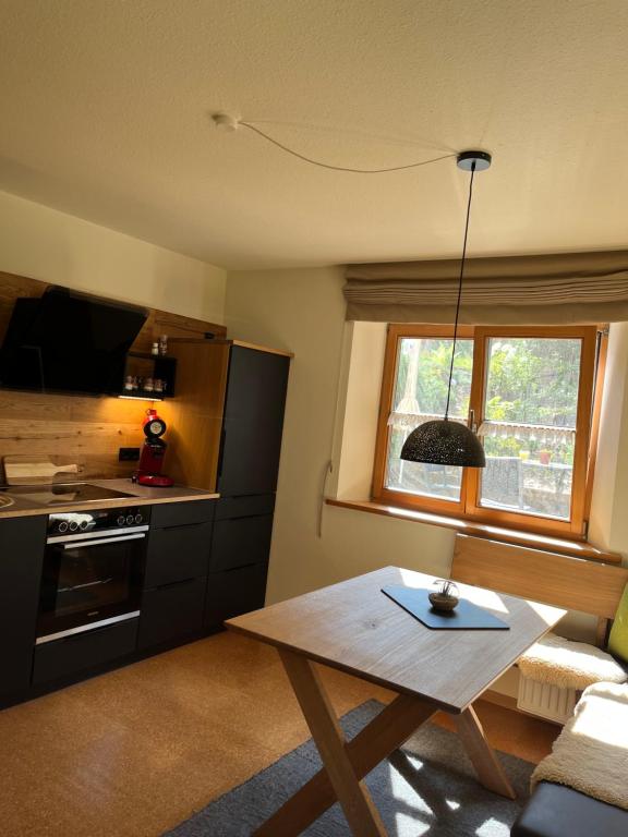 ein Wohnzimmer mit einem Tisch und einer Küche in der Unterkunft Mein Lieblingsplatz in Rettenberg
