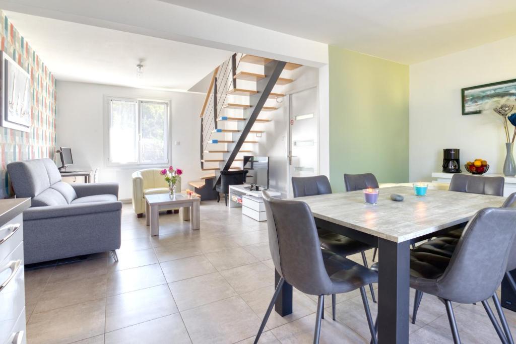 cocina y sala de estar con mesa y sillas en L'Odyssée, en Saint-Nic