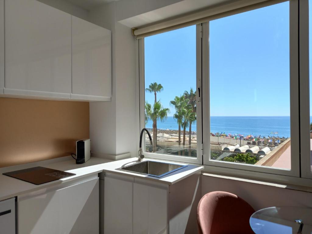 kuchnia ze zlewem i widokiem na plażę w obiekcie Torremolinos,estudio junto al mar en La Carihuela w mieście Torremolinos
