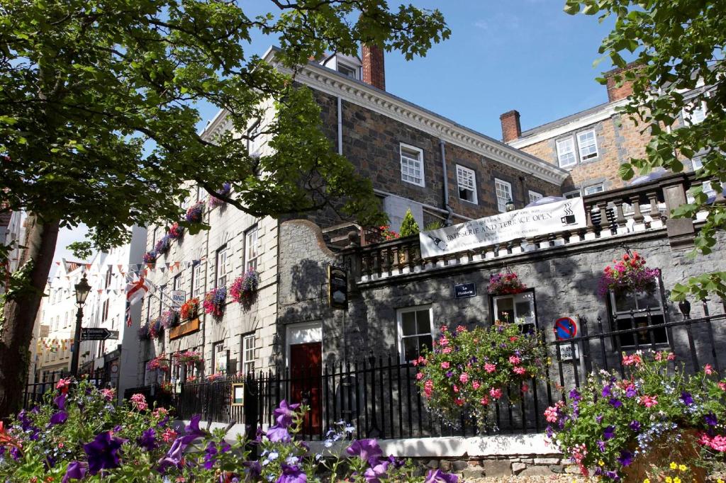 a building with flowers in front of it at Best Western Moores Central Hotel in St. Peter Port