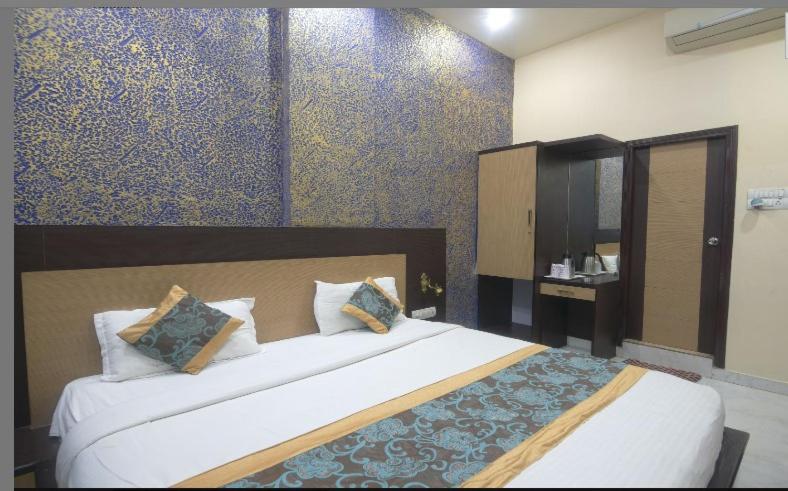 a bedroom with a large bed in a room at Hotel Vishnu Vilas in Rewa