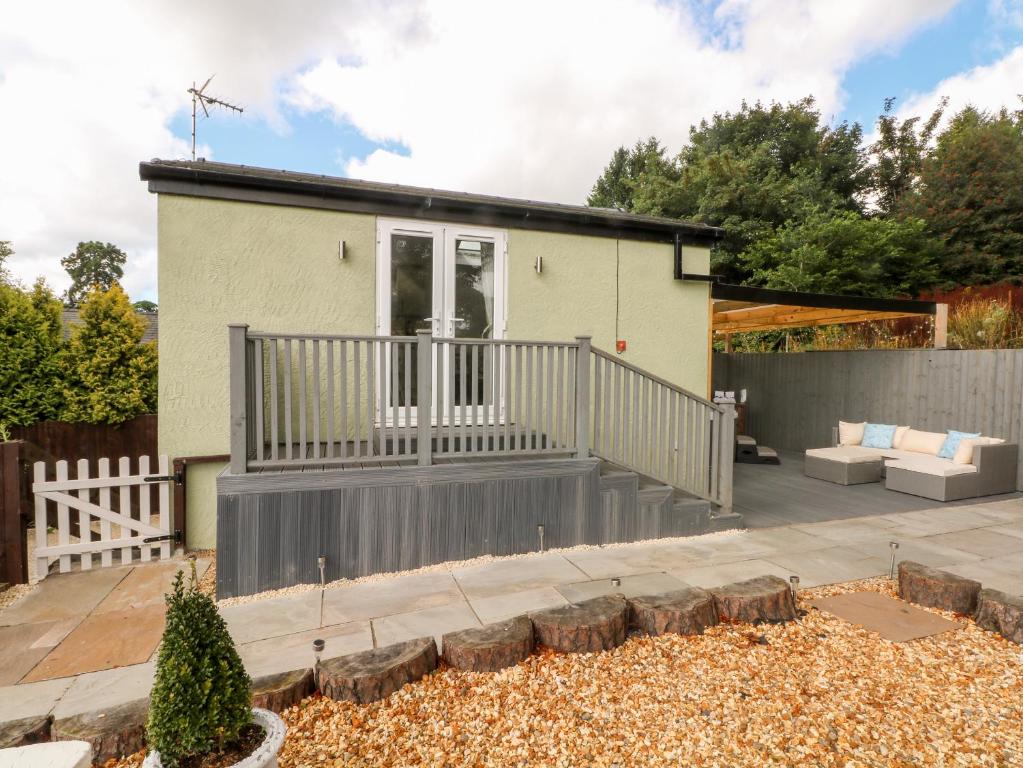 a house with a deck and a patio at Primrose Cottage in Mold