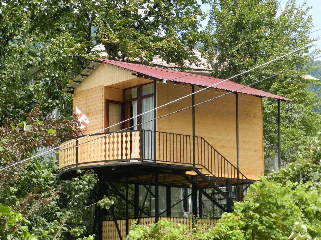 a tree house with a balcony in the trees at Cottage house in K'eda