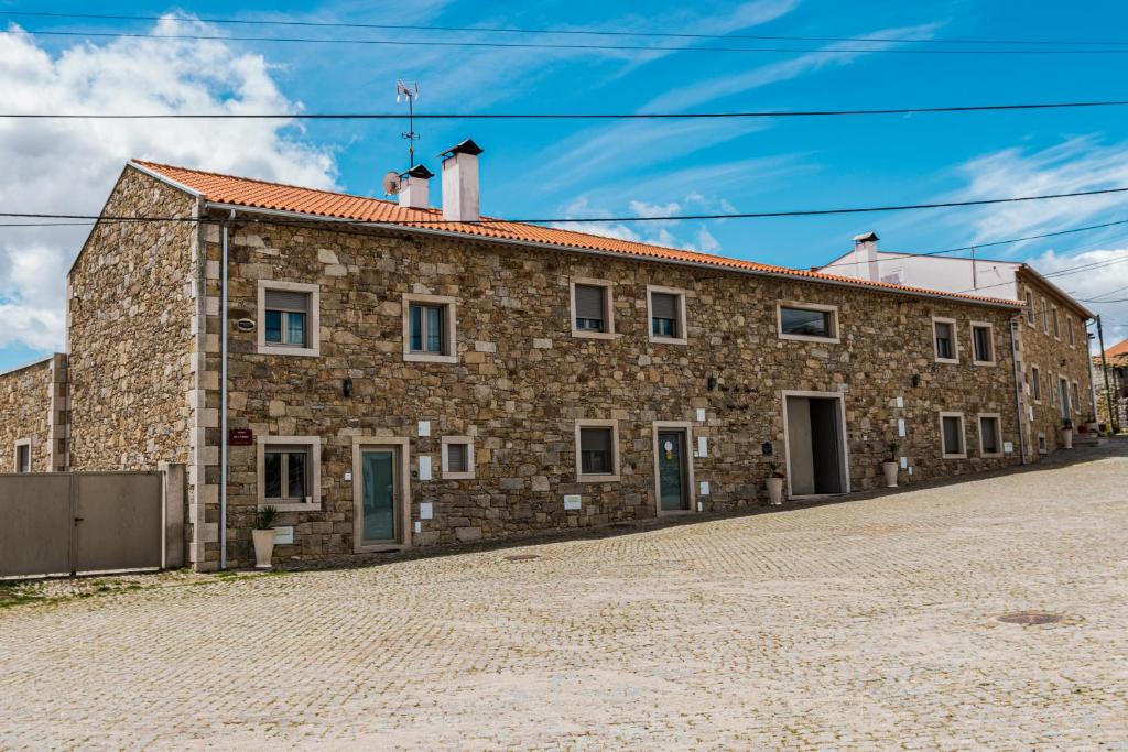 um antigo edifício de pedra numa rua de calçada em Casas Campo Cimo da Quinta em Miranda do Douro