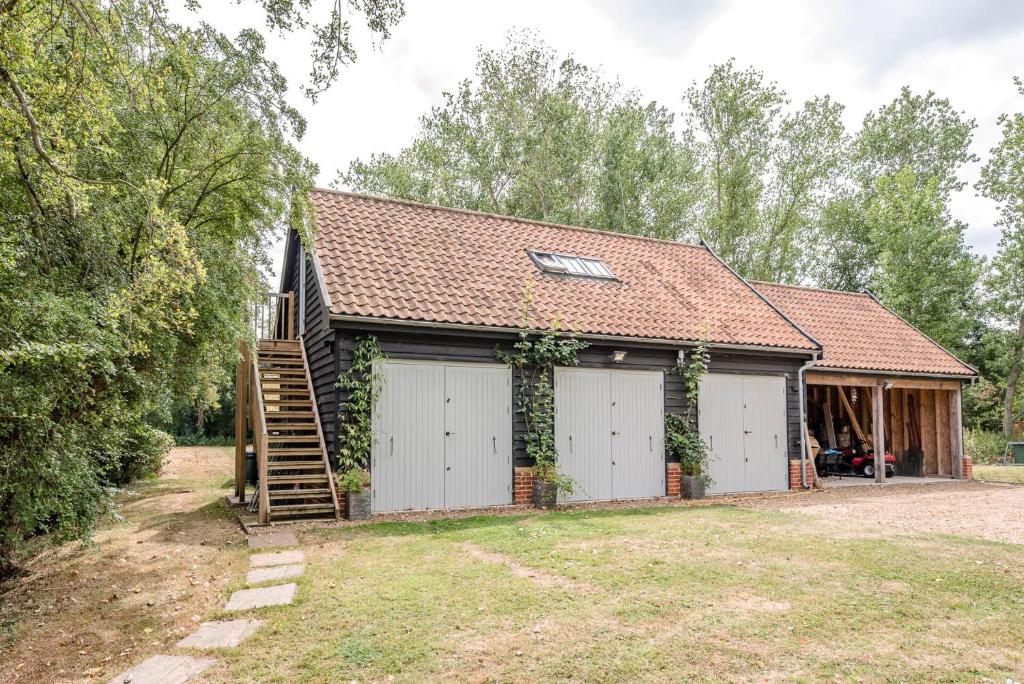 a house with two garage doors and a roof at Poplar Farm Cartlodge Earl Soham Air Manage Suffolk in Woodbridge