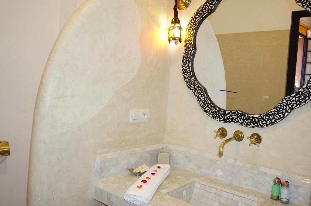 bagno con vasca e grande specchio di Riad New Moon a Marrakech