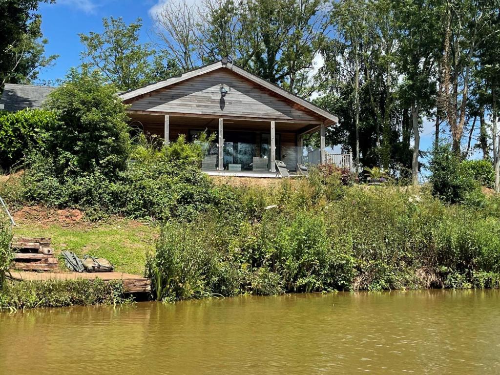 a house on the shore of a river with a body of water at Oak Lodge, South View Lodges, Exeter in Exeter