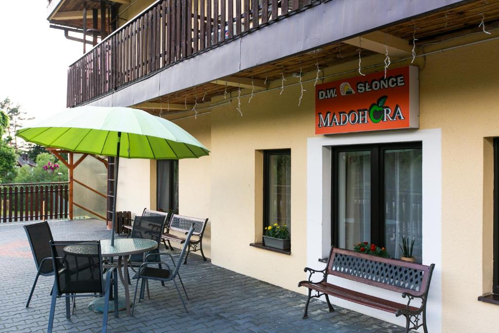 a patio with a table and chairs and an umbrella at MADOHORA_SŁOŃCE in Zaryte