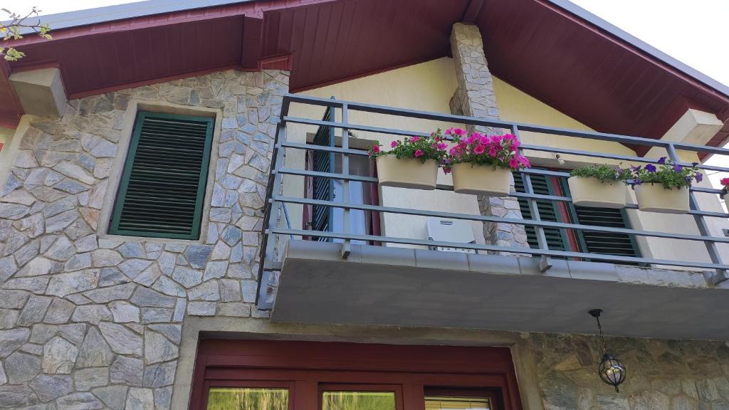 a building with a balcony with flowers on it at Jovanov Residence - Remote & Accessible in Dolna Matka