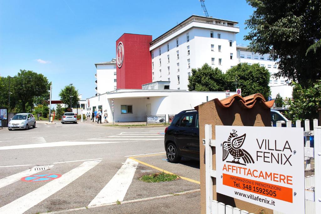 ein Schild an der Seite einer Straße mit einem Gebäude in der Unterkunft VILLA FENIX OSIO SOTTO 2 in Osio Sotto