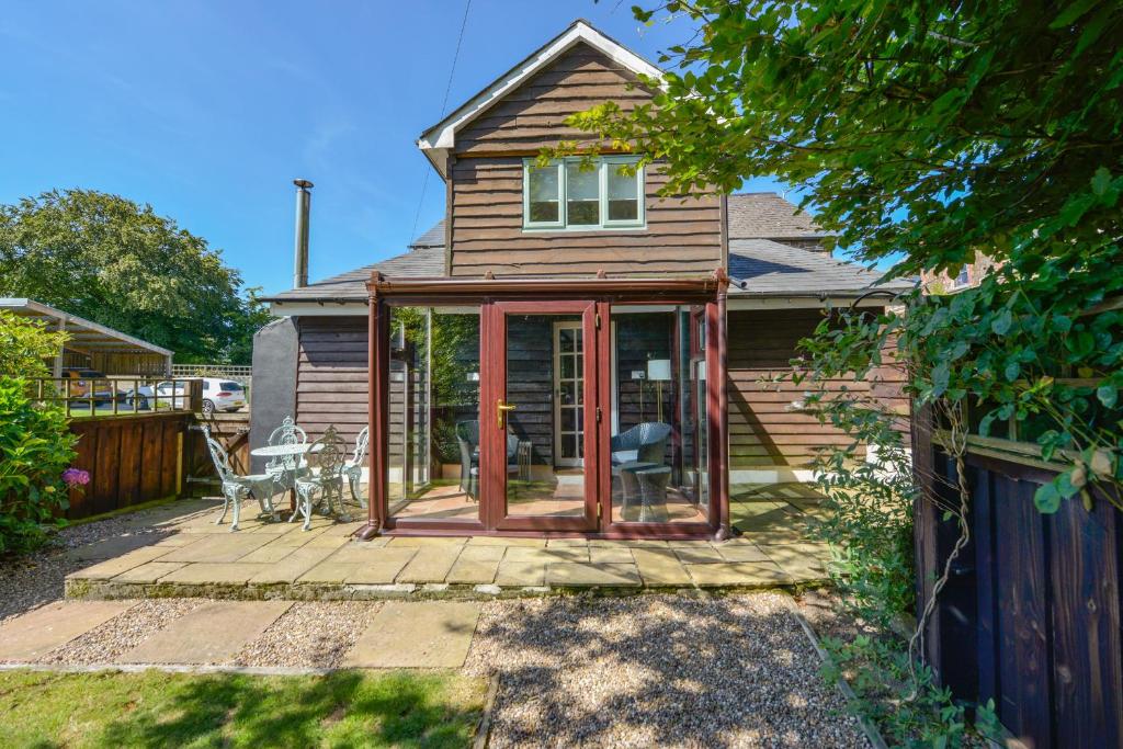 a house with a screened in porch with a table at Kingfisher Cottage in Holsworthy