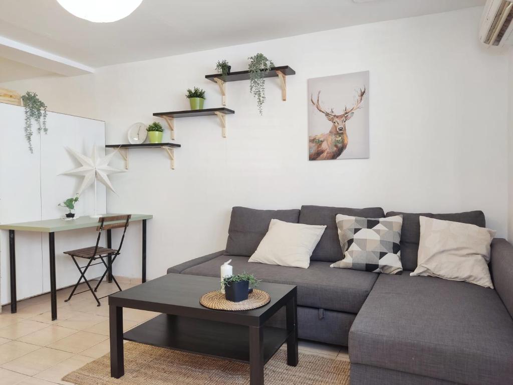 een woonkamer met een grijze bank en een tafel bij Willy Brandt Studios - Best Location in Tel Aviv