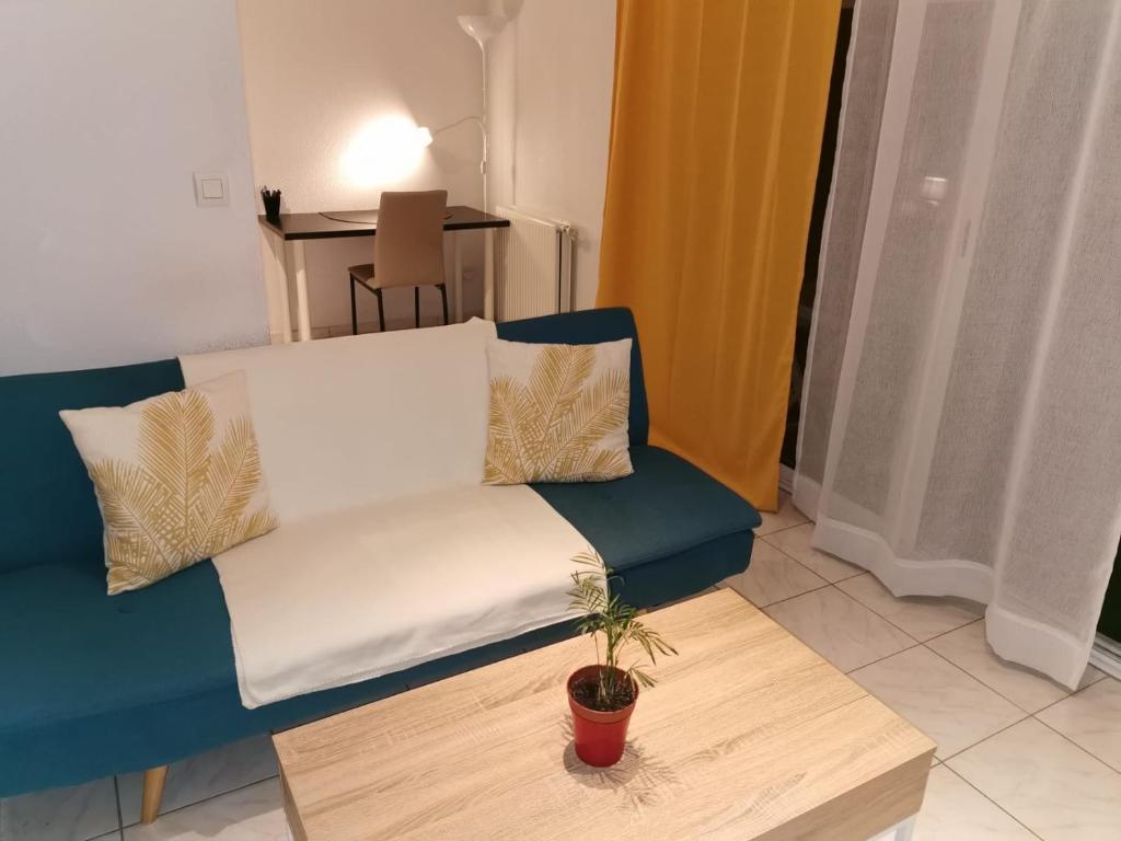 ein blaues Sofa und einen Couchtisch im Wohnzimmer in der Unterkunft Appart T1bis Malbosc in Montpellier