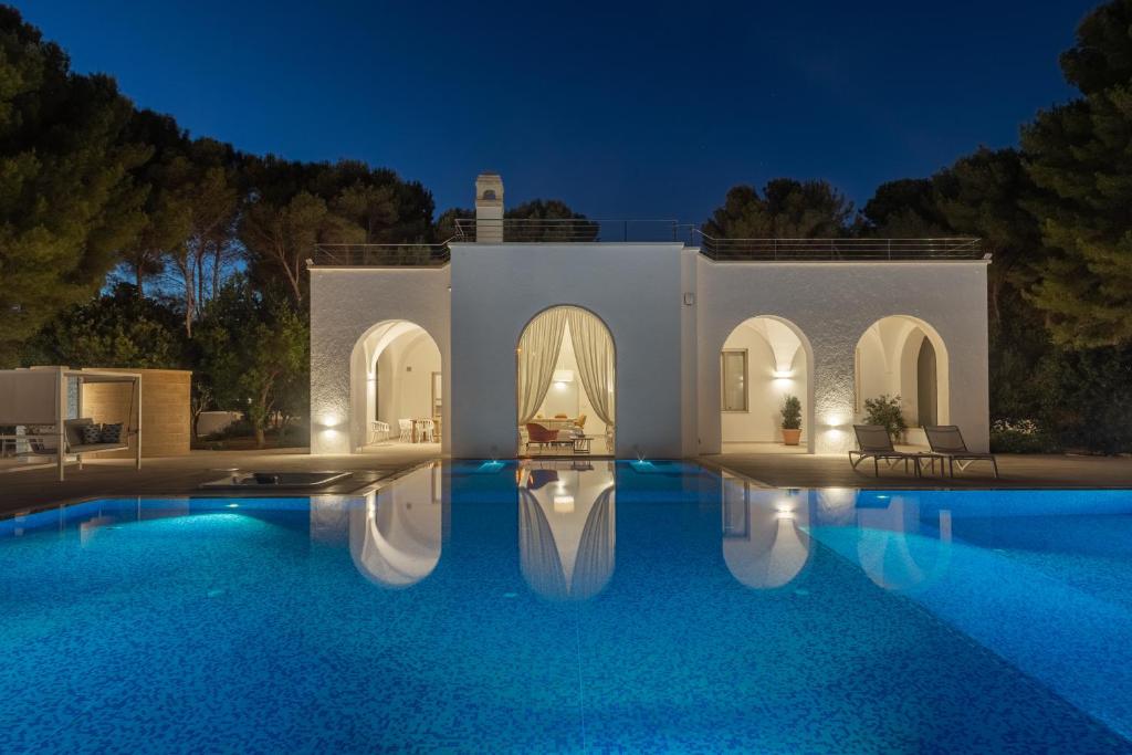 una villa con piscina di notte di VILLA ROSA MEDITERRANEA a Marina di Pescoluse