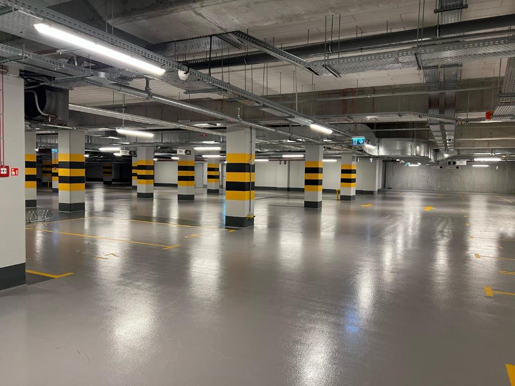 an empty parking garage with yellow and black poles in it at ibis Styles Kraków Centrum in Krakow