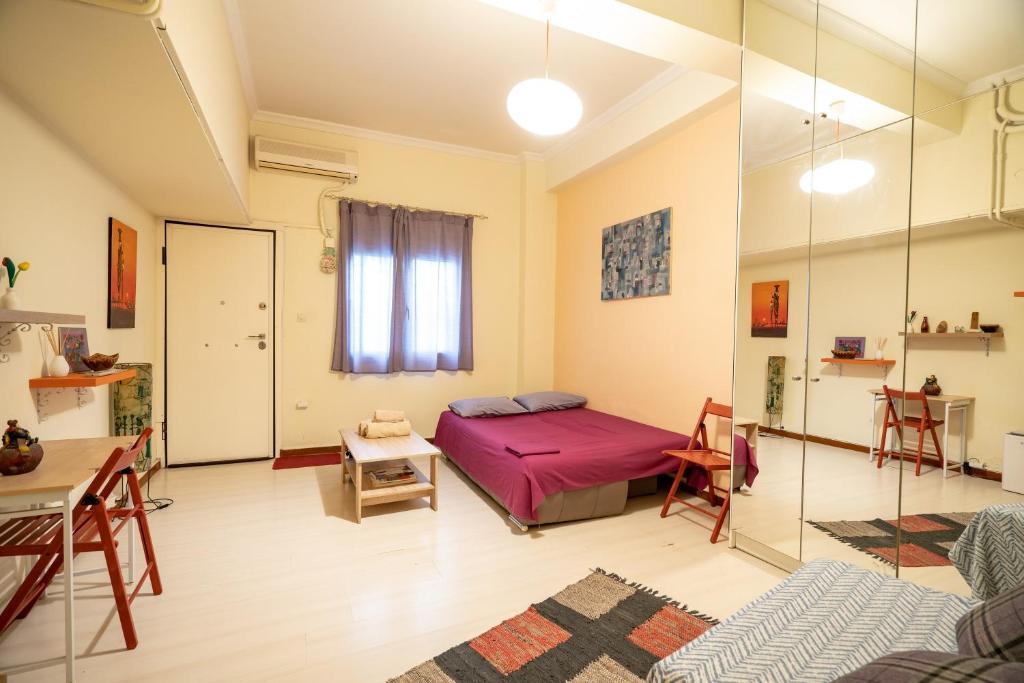 una camera con letto, tavolo e specchio di Independent Apartment at Lykavitos 1 bed 2 pers ad Atene