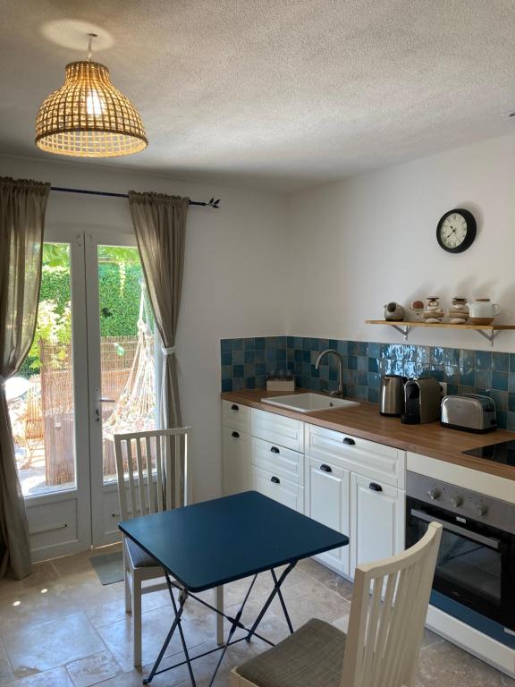 uma cozinha com uma mesa azul e cadeiras em Cabanon Ecurie Maestoso em Lançon-Provence
