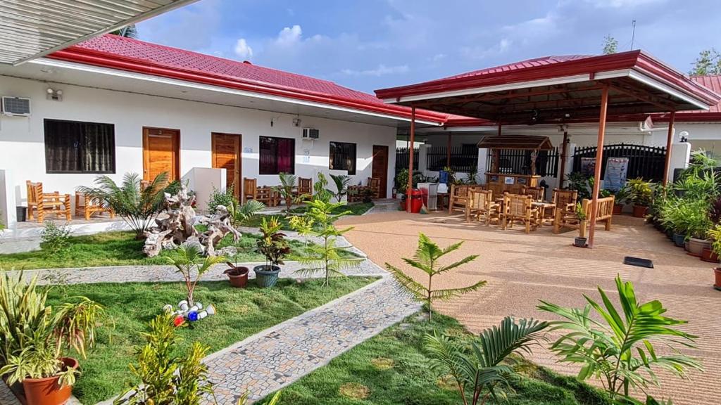 a house with a patio with tables and chairs at Babas Guesthouse in Moalboal