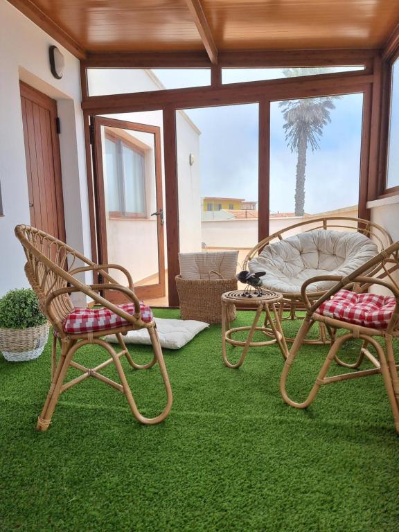 Apartamento La Villa في فالفيردي: كرسيين وطاولة في غرفة مع عشب