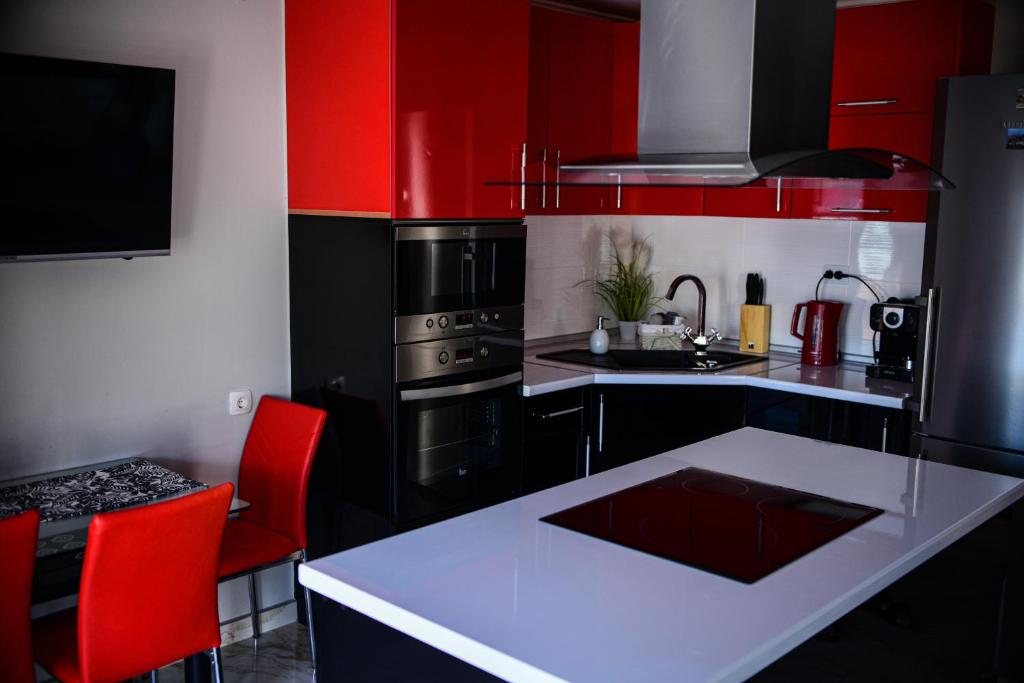 a kitchen with red cabinets and a white counter top at Medius Park Apartment in Sandanski
