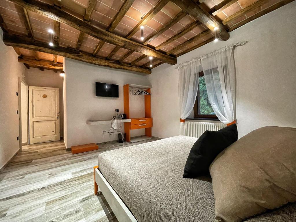1 dormitorio con cama, ventana y escritorio en Il Gaudente B&B, en Santa Fiora