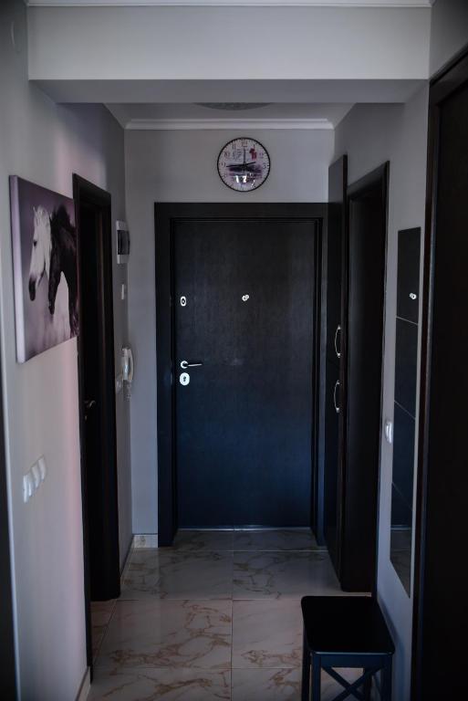 a hallway with a door and a clock on the wall at Medius Park Apartment in Sandanski