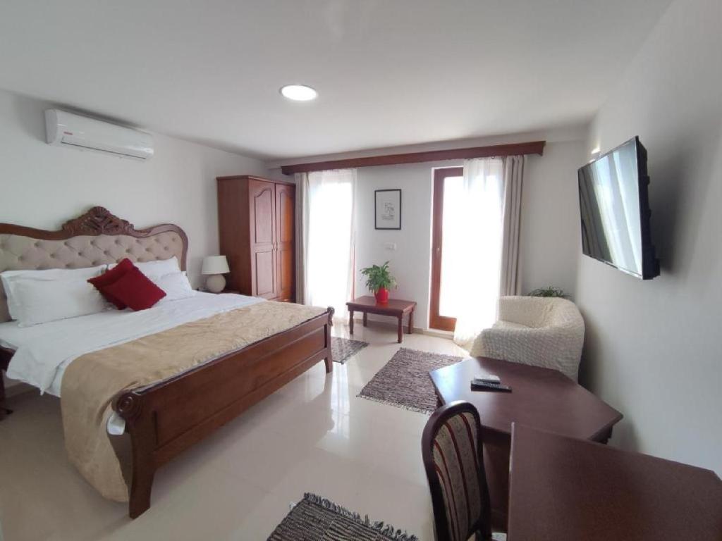 a bedroom with a bed and a table and a chair at Citadela Old Town - Gelateria in Ulcinj
