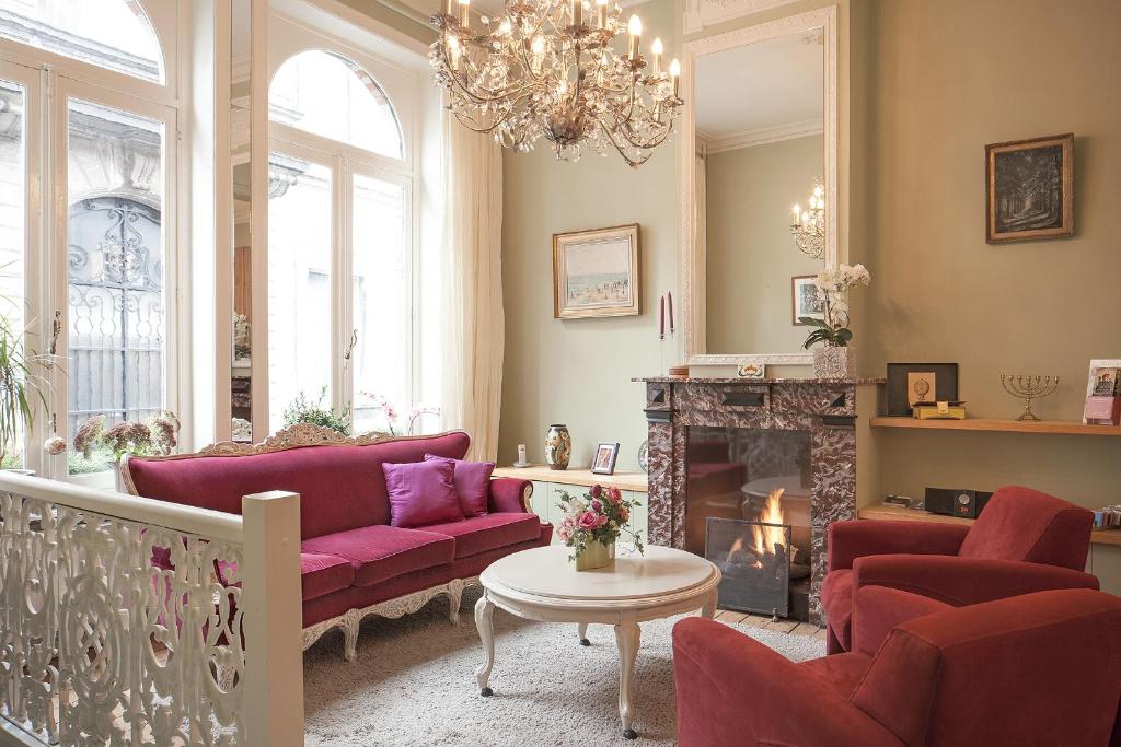 a living room with purple couches and a fireplace at B&B In Bruges in Bruges