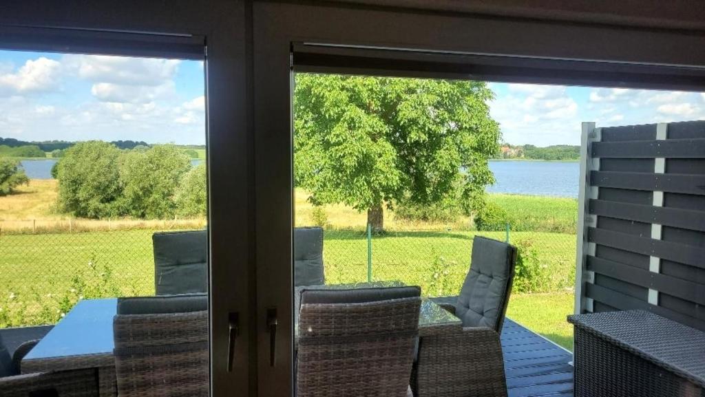 a screened in porch with a view of the water at Ferienhaus am See in Klein Upahl