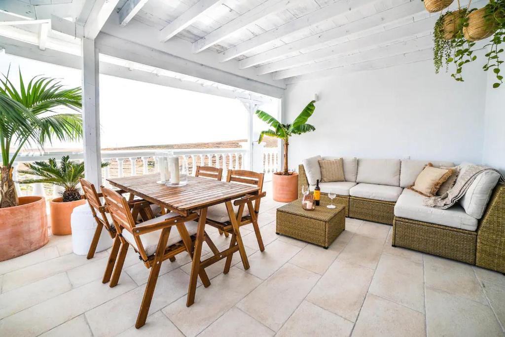 een woonkamer met een houten tafel en stoelen bij Las Nieves Suites in Teguise