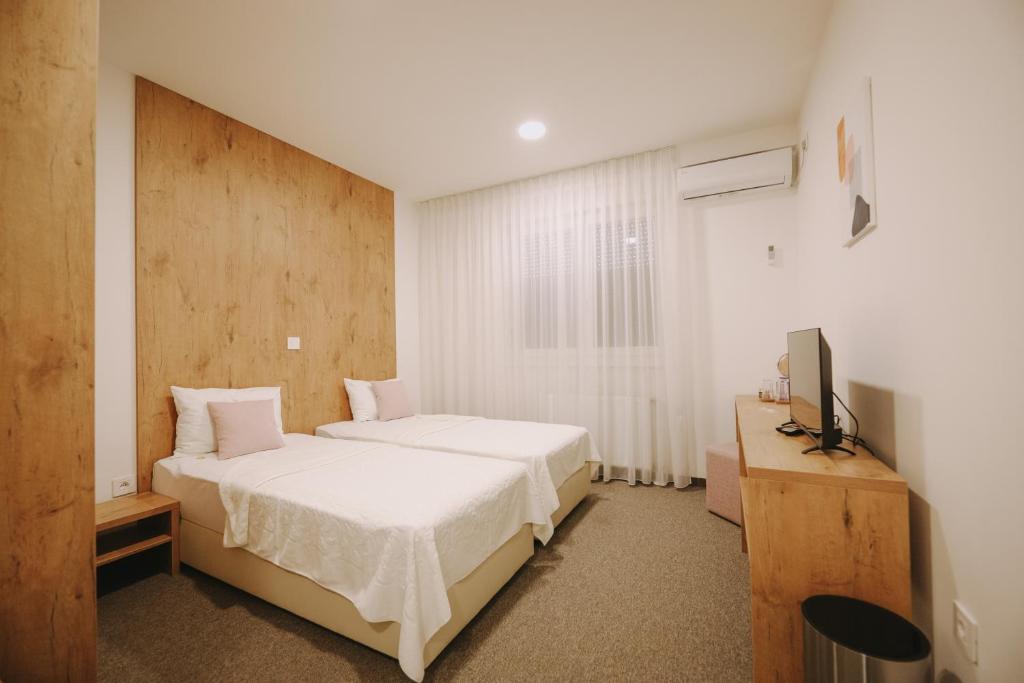 1 dormitorio con 1 cama y TV en ATOS Centar, en Čelinac