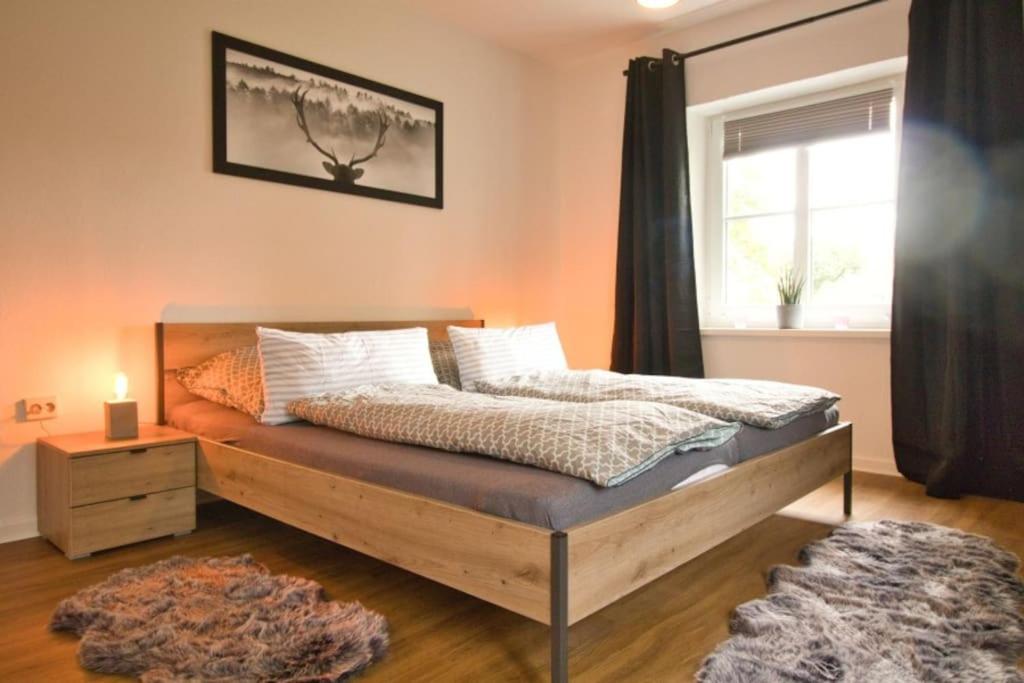 Schlafzimmer mit einem Bett und einem Fenster in der Unterkunft Ferienhaus Haas - Am Heidschnuckenweg in Faßberg
