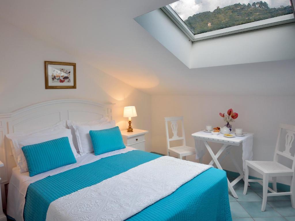 a bedroom with a bed and a table with chairs at Torre Paradiso in Minori