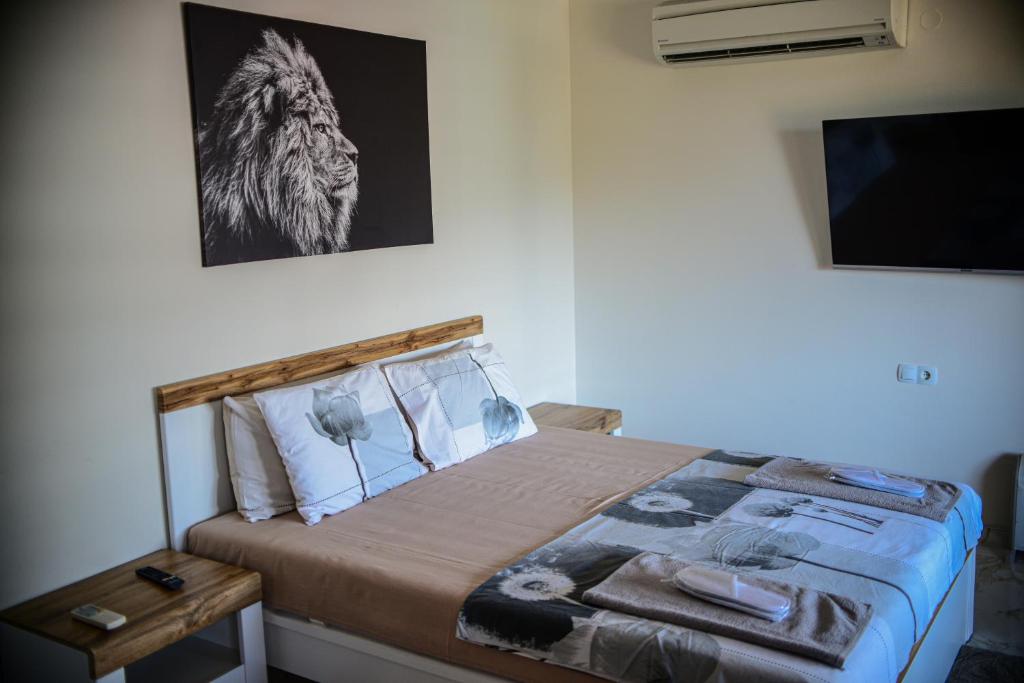 a bedroom with a bed with a wooden head board at Medius Park Apartment in Sandanski