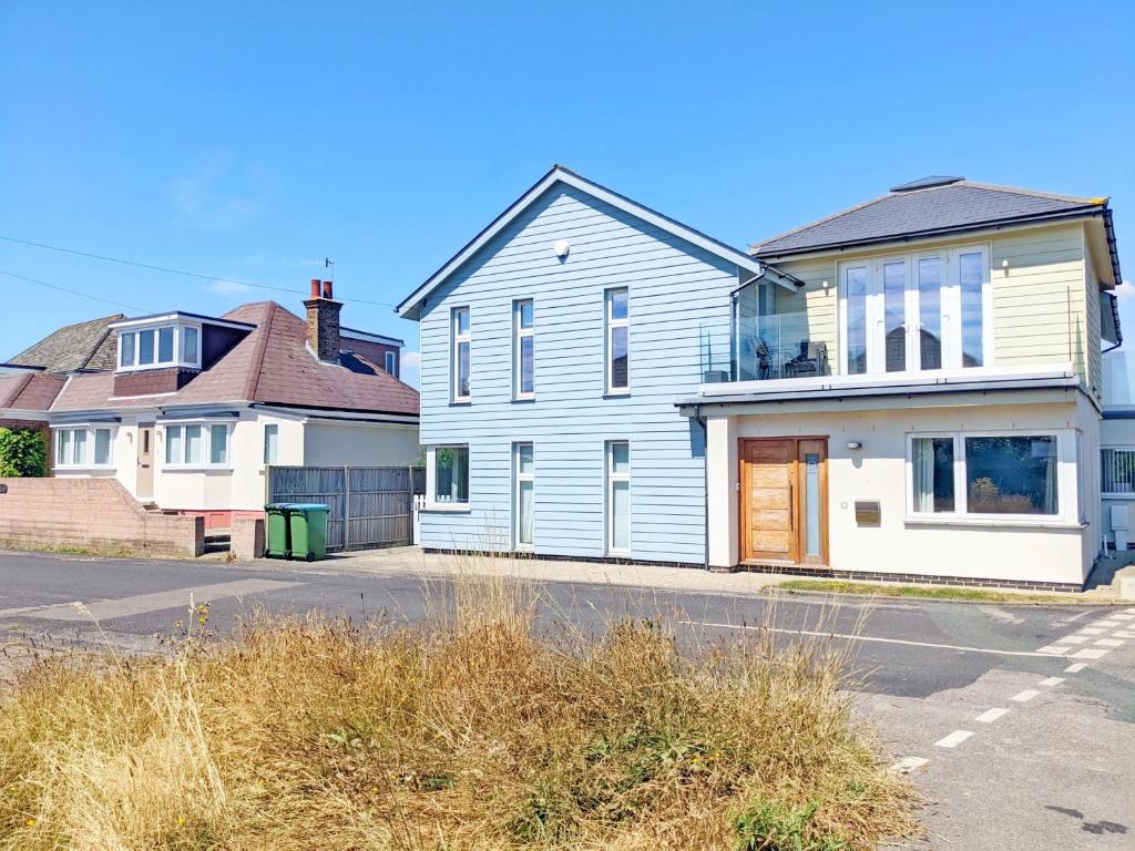 a white house on a street with two other houses at Innisfree, Middleton on Sea in Middleton-on-Sea