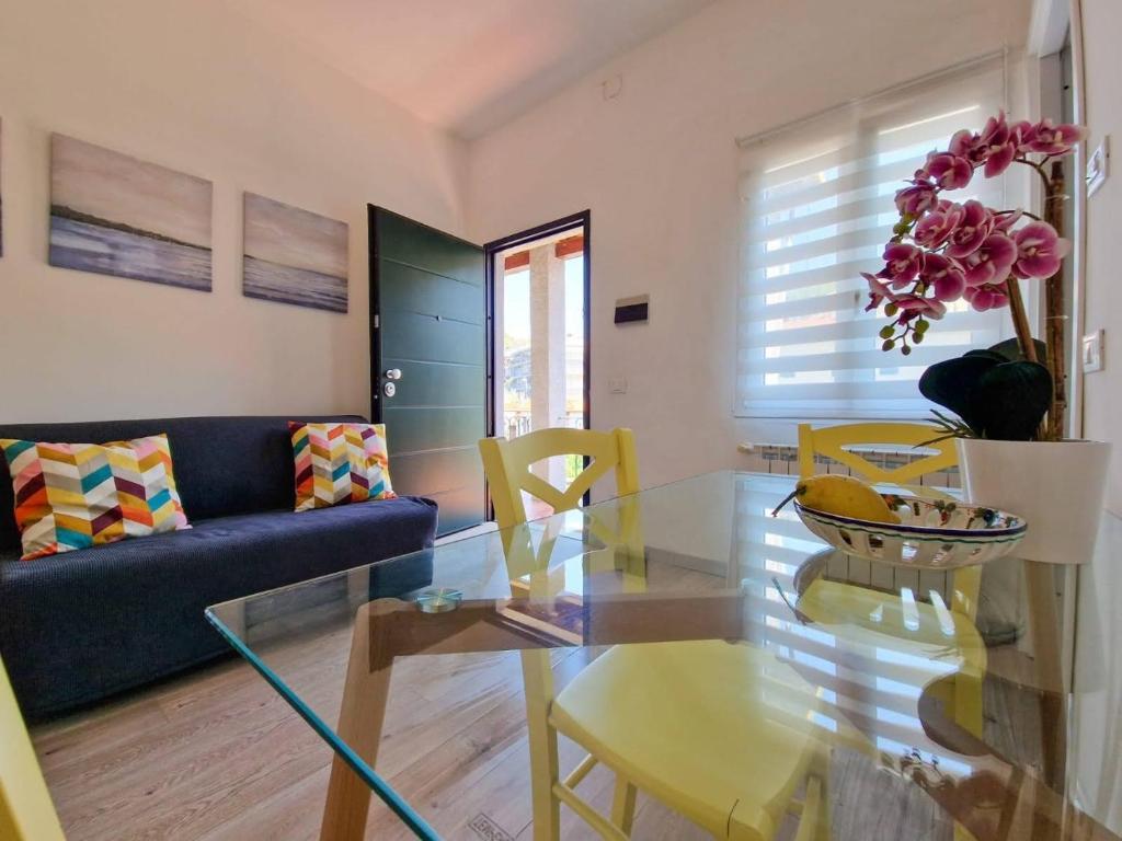 uma sala de estar com uma mesa de vidro e um sofá azul em Ela dream em La Spezia